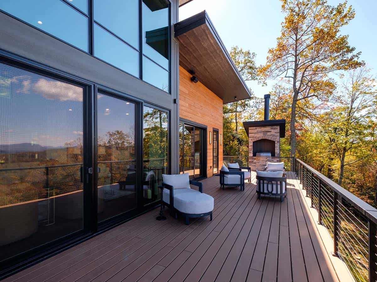 Deck seating area with wood-fired pizza oven and stone chimney