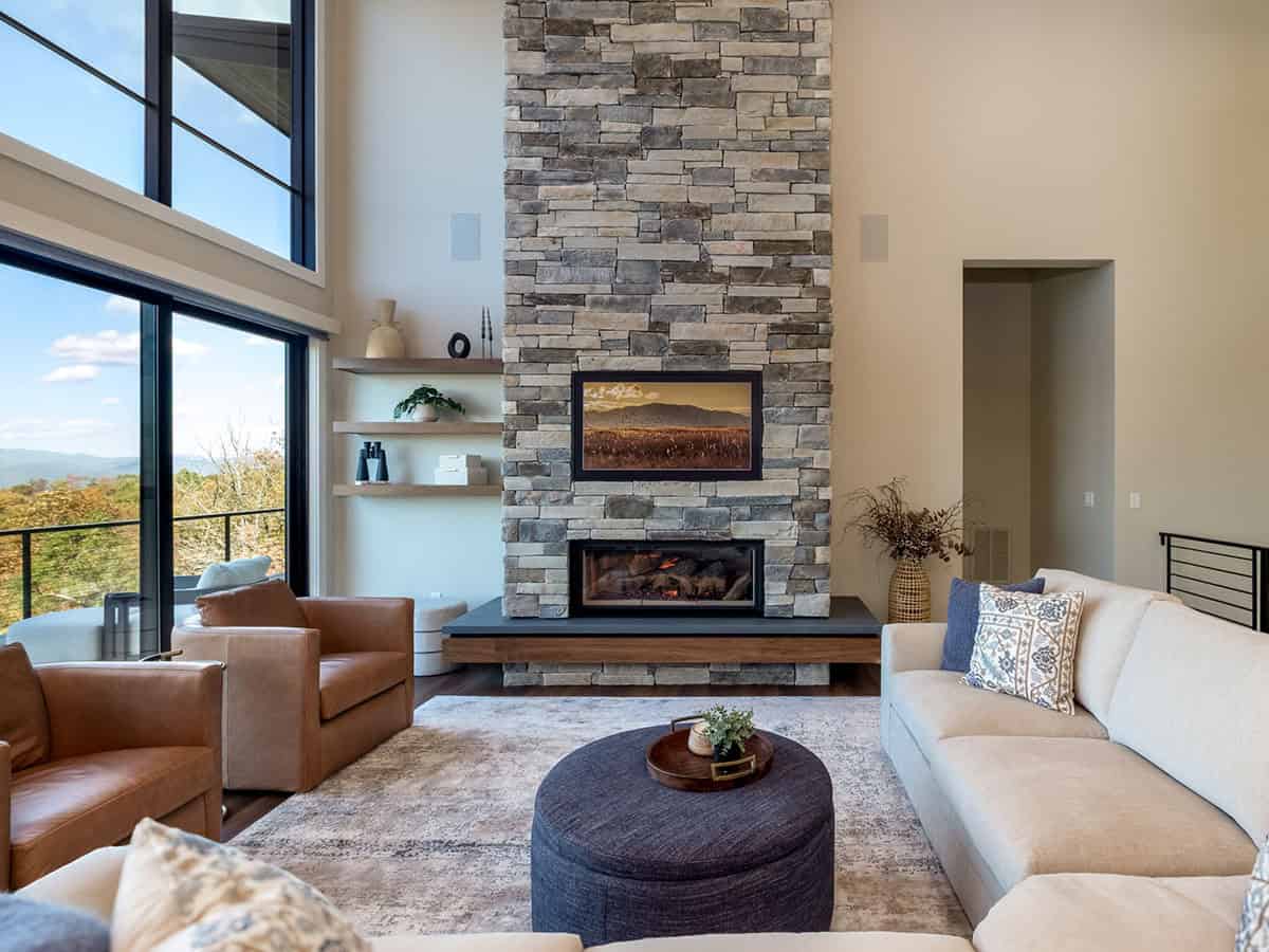 Living room with leather chairs and floor-to-ceiling stacked stone fireplace
