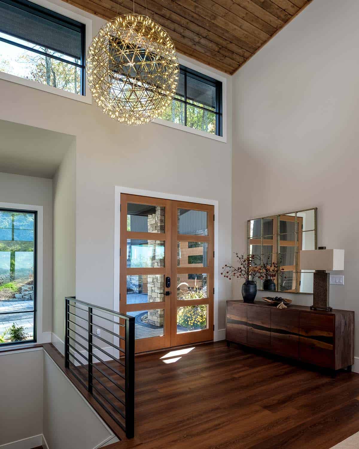 Two-story entry with sculptural pendant light and wood console