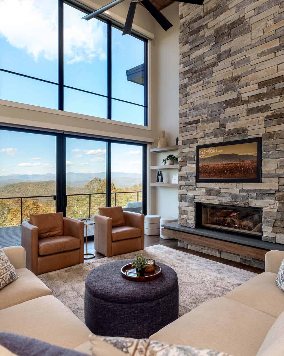 Great room seating with leather armchairs and stone fireplace wall