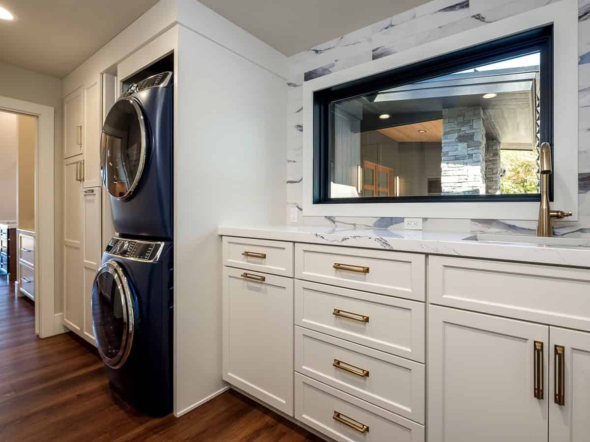 Laundry room with stacked washer dryer and marble backsplash window
