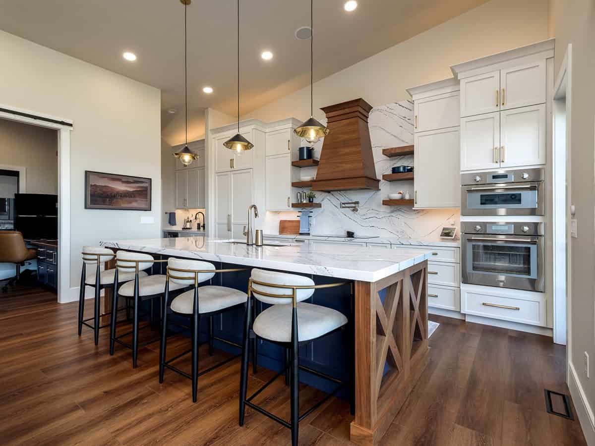 Kitchen island seating with walnut hood and marble backsplash