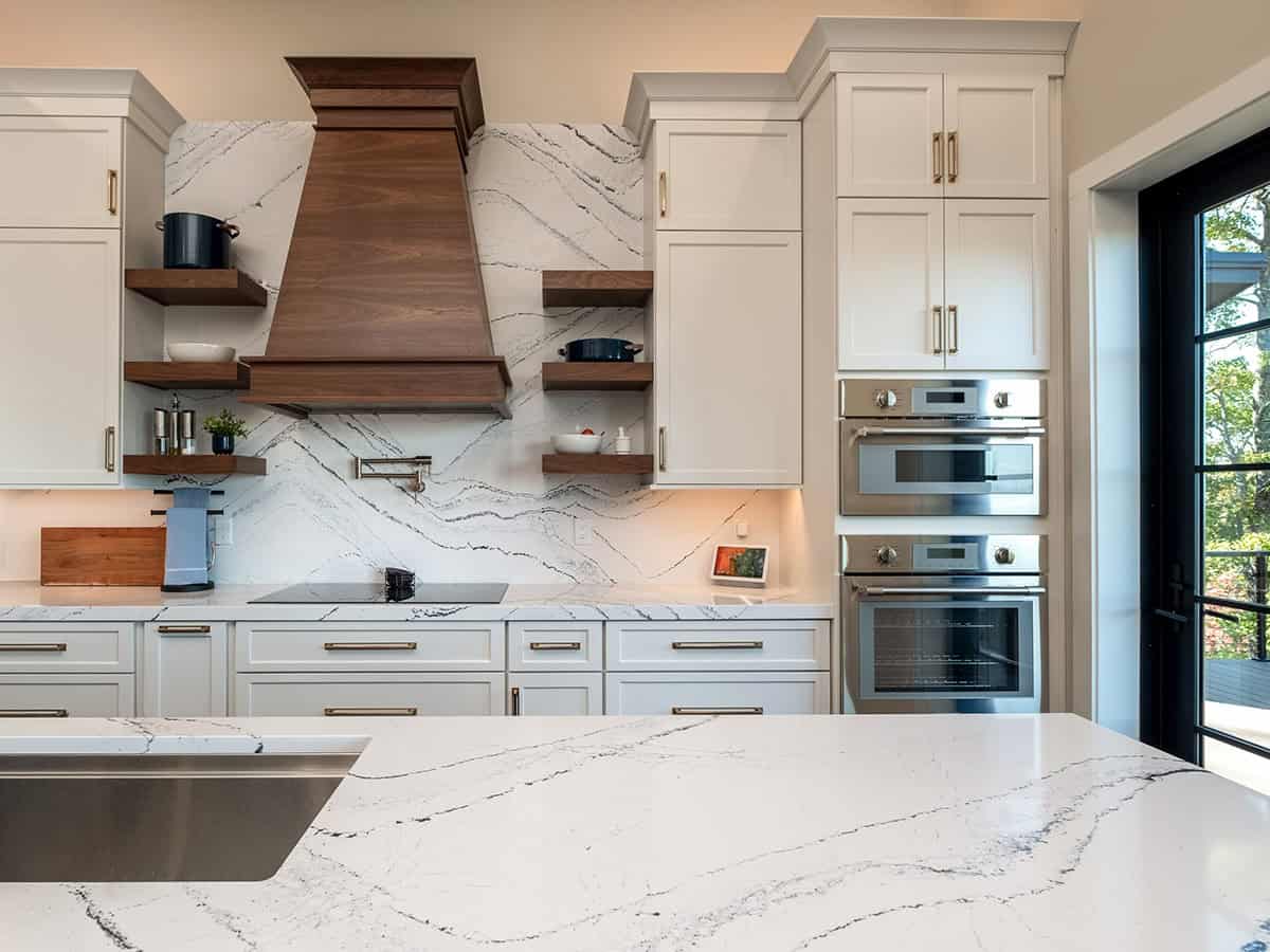Kitchen backsplash detail with walnut hood and floating shelves