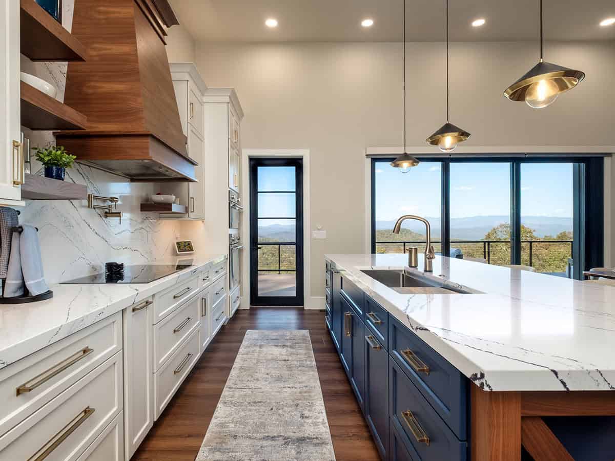 Galley kitchen view toward blue island and glass door