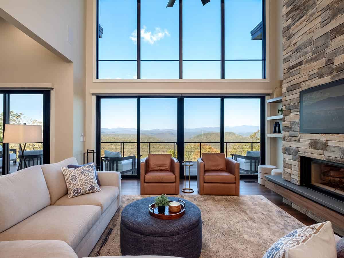 Living room seating facing floor-to-ceiling mountain view windows