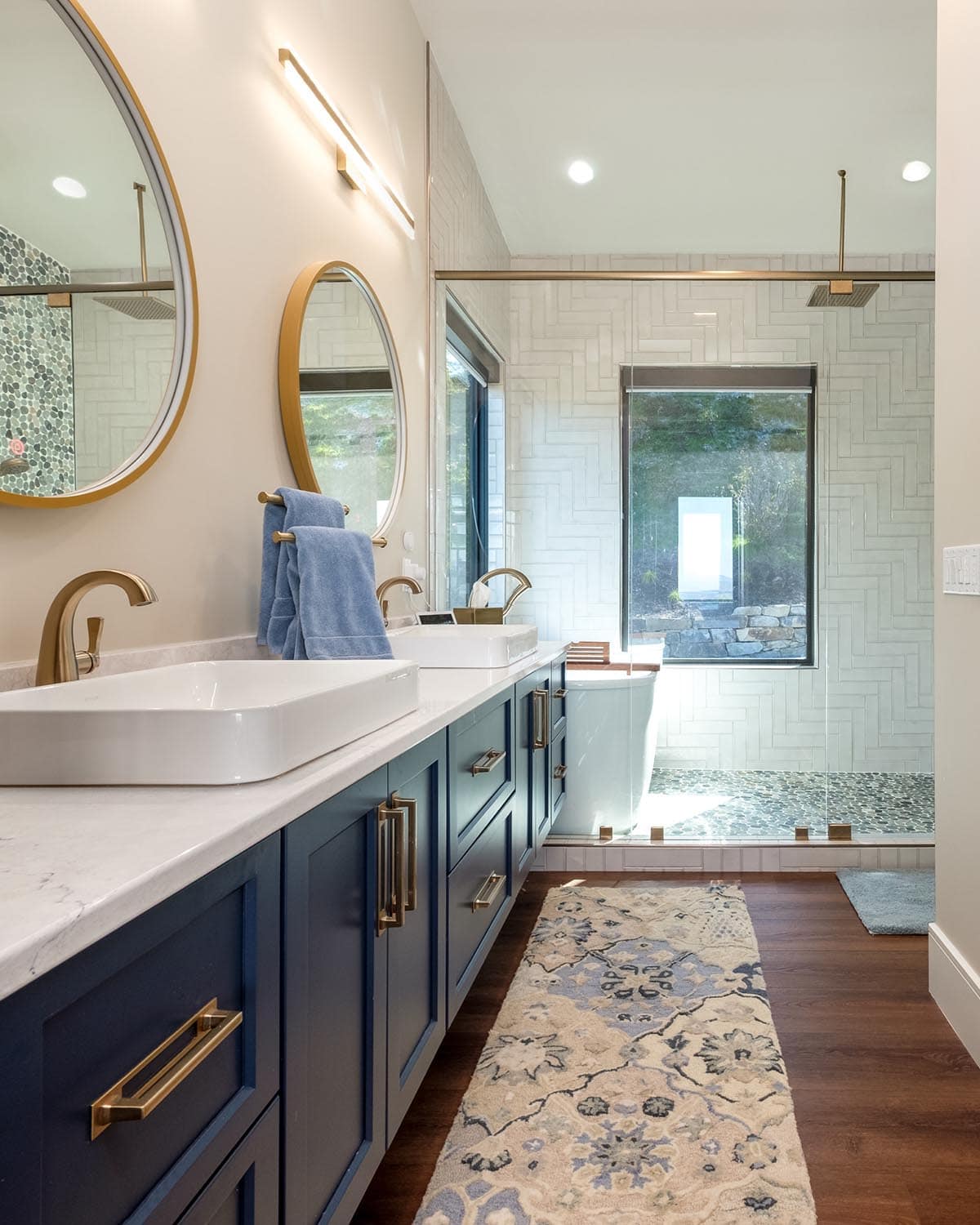 Primary bathroom with dual round mirrors and walk-in shower