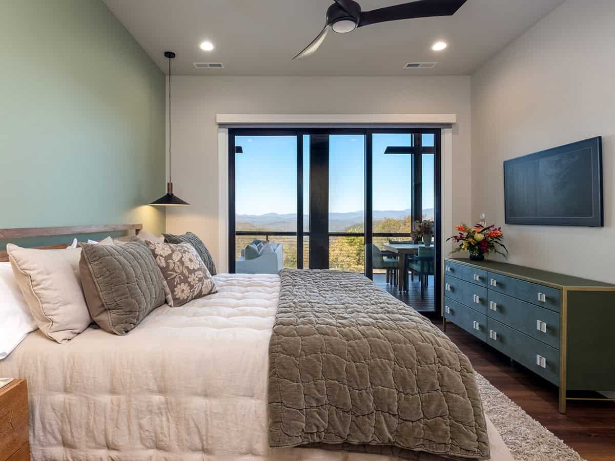Bedroom with sage accent wall and blue dresser TV console