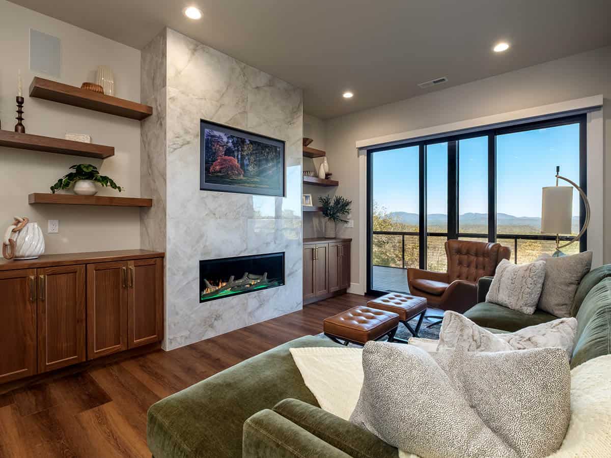 Lower level lounge with olive sectional and marble fireplace