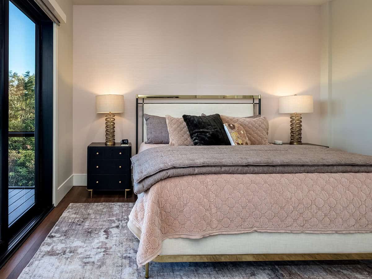 Bedroom with brass nightstand lamps and mountain-facing window