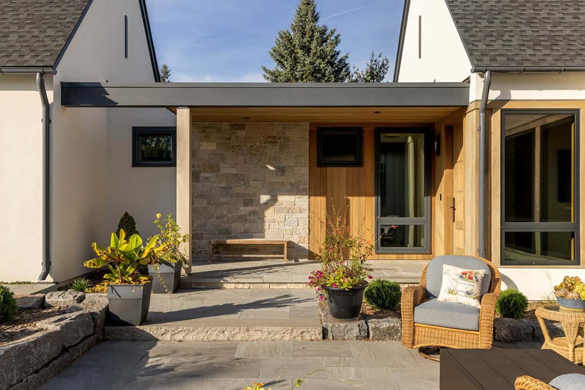 Stone and cedar entry with wraparound covered porch at sunset