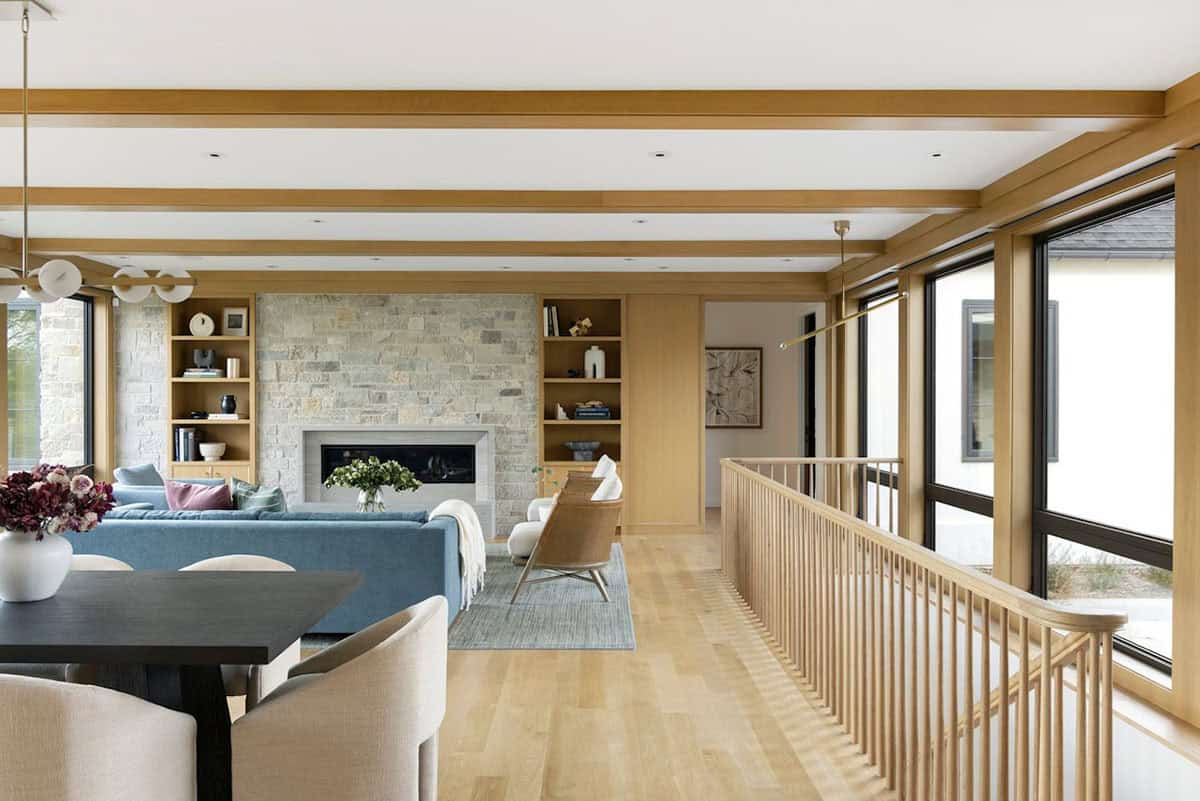 Living room with stone fireplace, built-ins, and blue sectional sofa