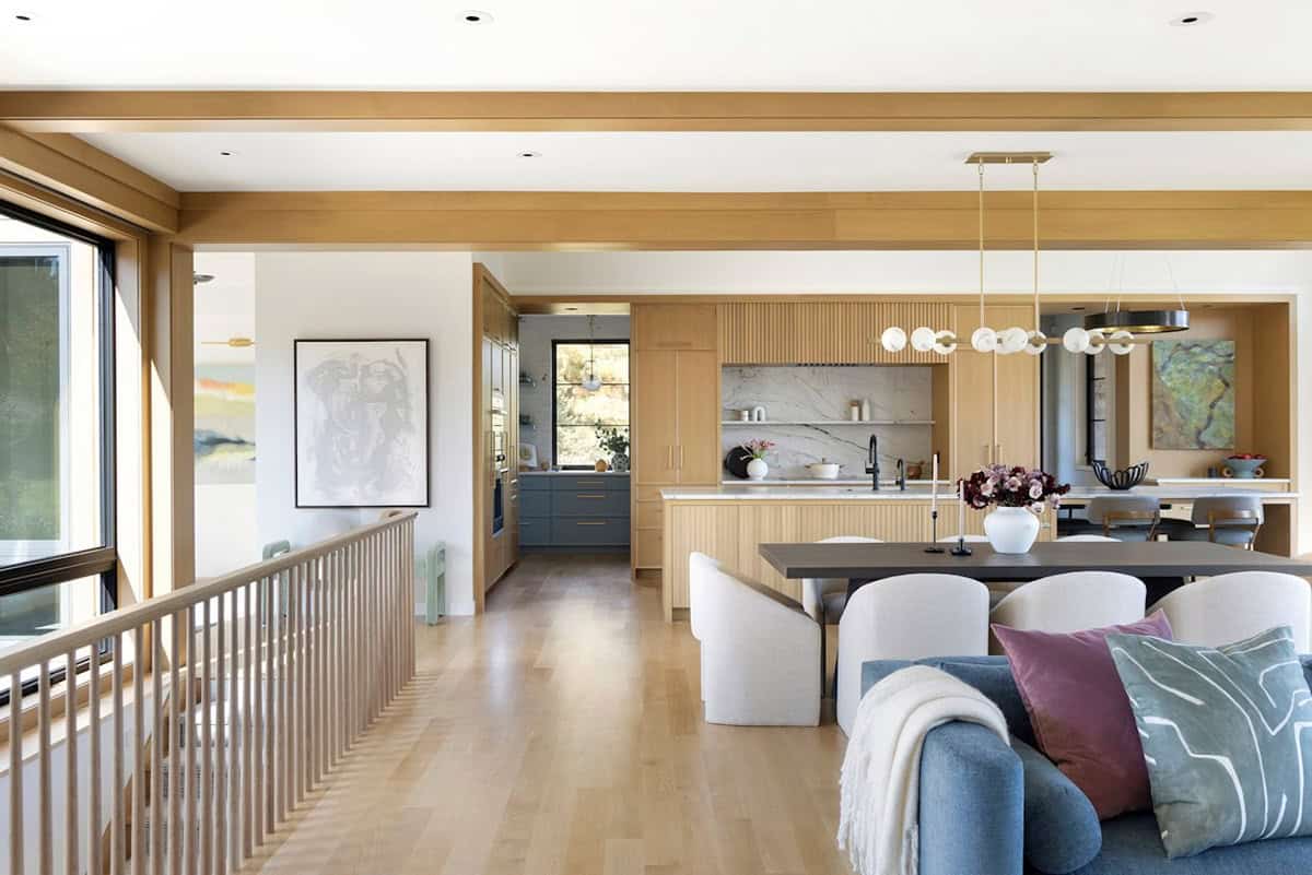 Open kitchen and dining area viewed from upstairs wood railing