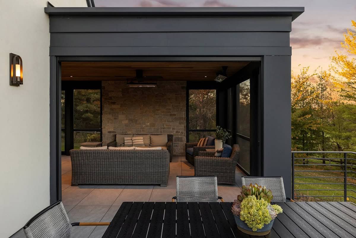 Screened porch with wicker furniture and stone accent wall