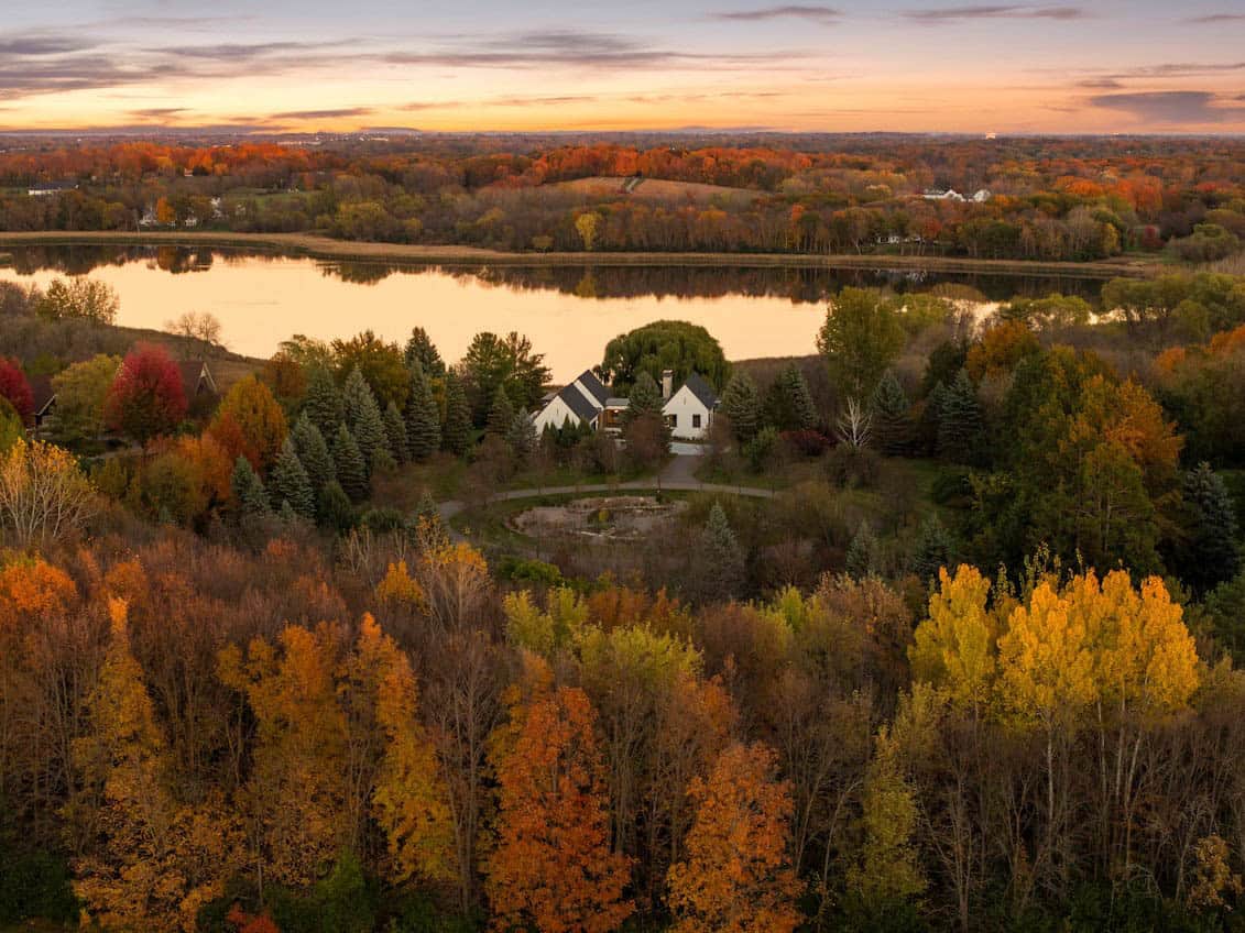 Aerial view of lakeside property framed by fall foliage