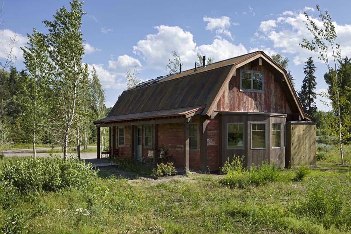 Weathered red barn structure with gambrel roof and porch