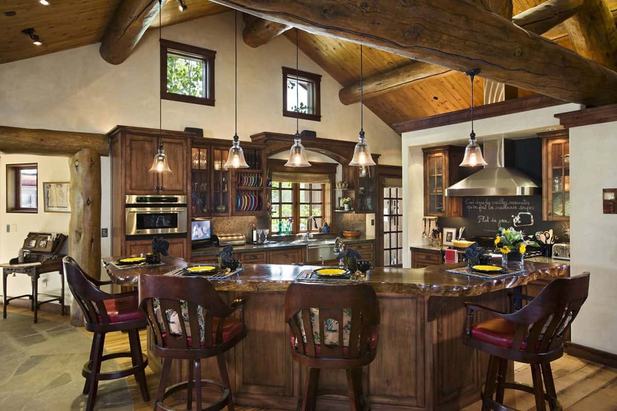 Log beam kitchen with pendant lighting and live edge island