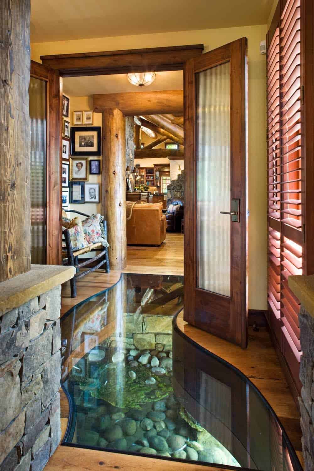 Glass floor entry revealing stream stones beneath log timbers