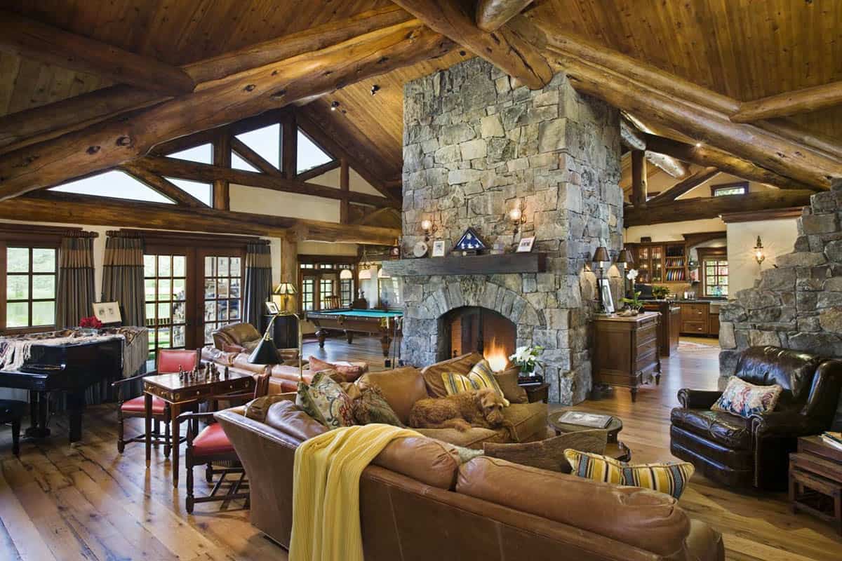 Great room with soaring log trusses and stone fireplace