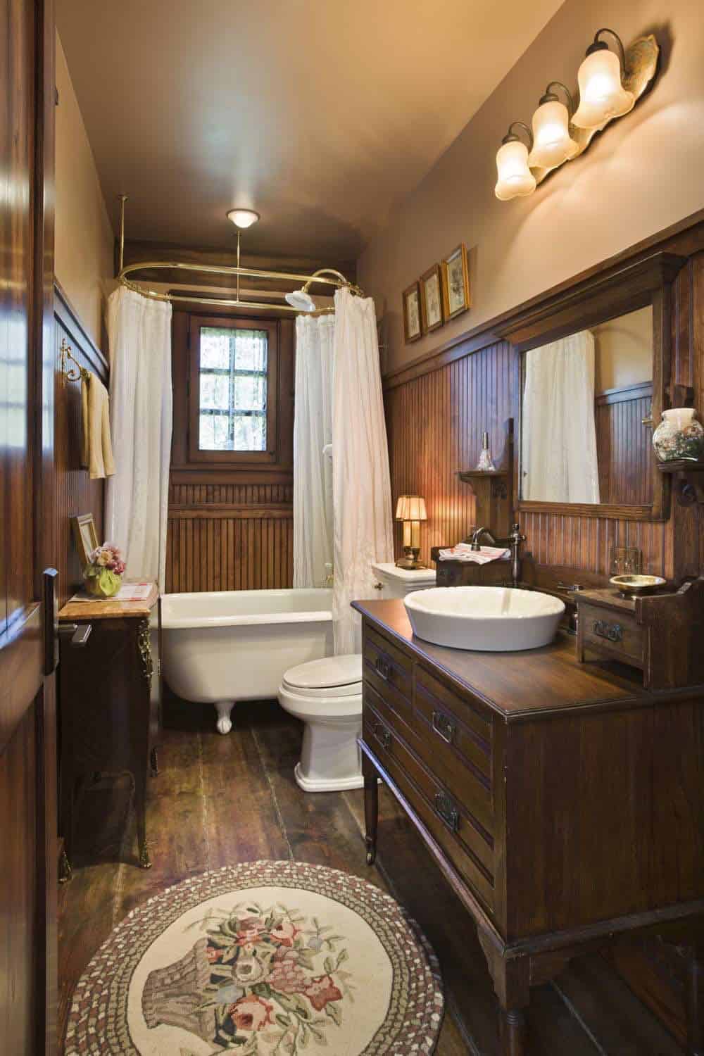 Bathroom with clawfoot tub and dark wood wainscoting