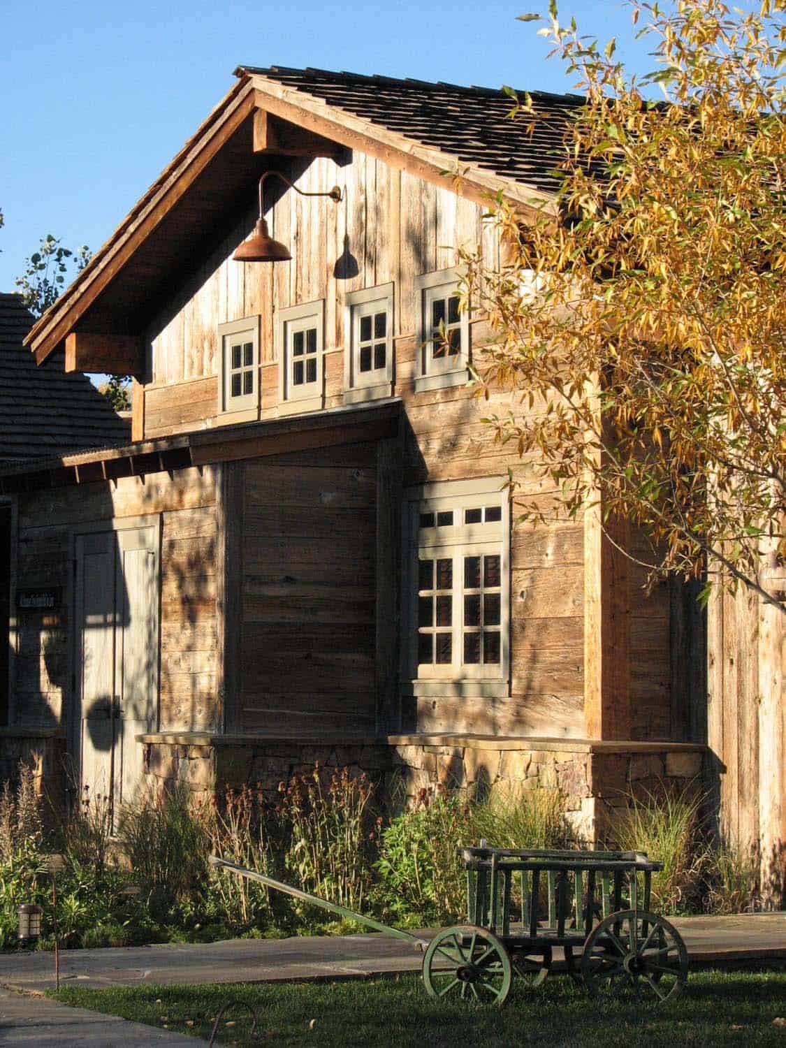 Weathered barn exterior with dormer windows and antique wagon