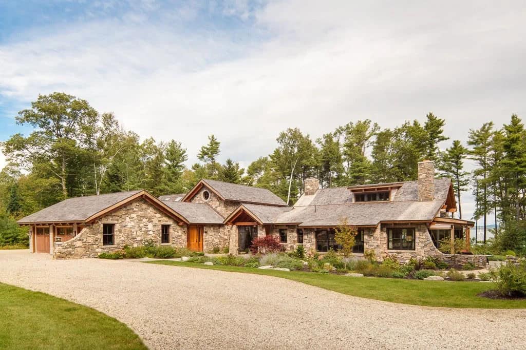 Stone and timber coastal home with cedar shingle roof and curved gravel drive