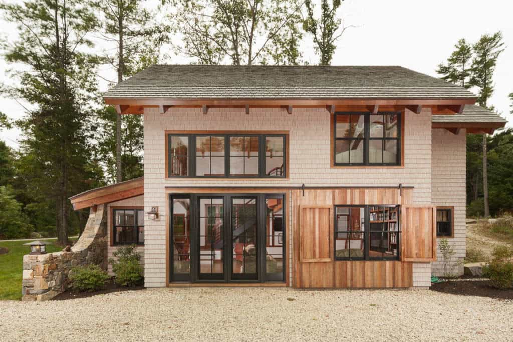 Shingled barn with black-framed French doors and sliding cedar shutters