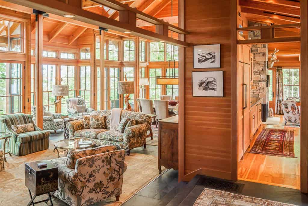 Living room framed by tall windows, floral upholstery, and slate floors