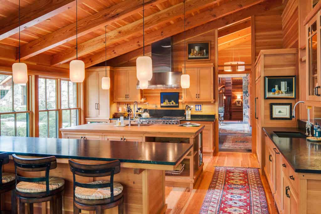 Cedar kitchen with soapstone counters, pendant lights, and a double island