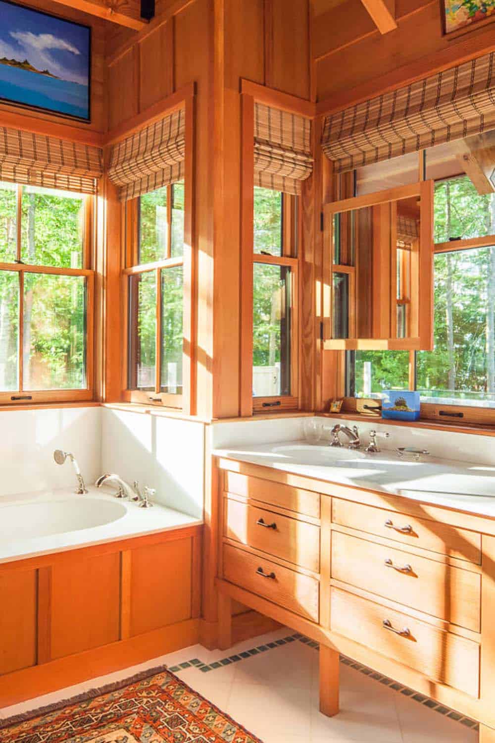 Primary bathroom with corner windows, soaking tub, and double wood vanity