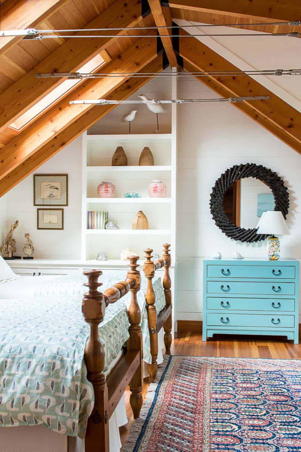 Attic guest room with twin beds, built-in shelving, and a turquoise dresser