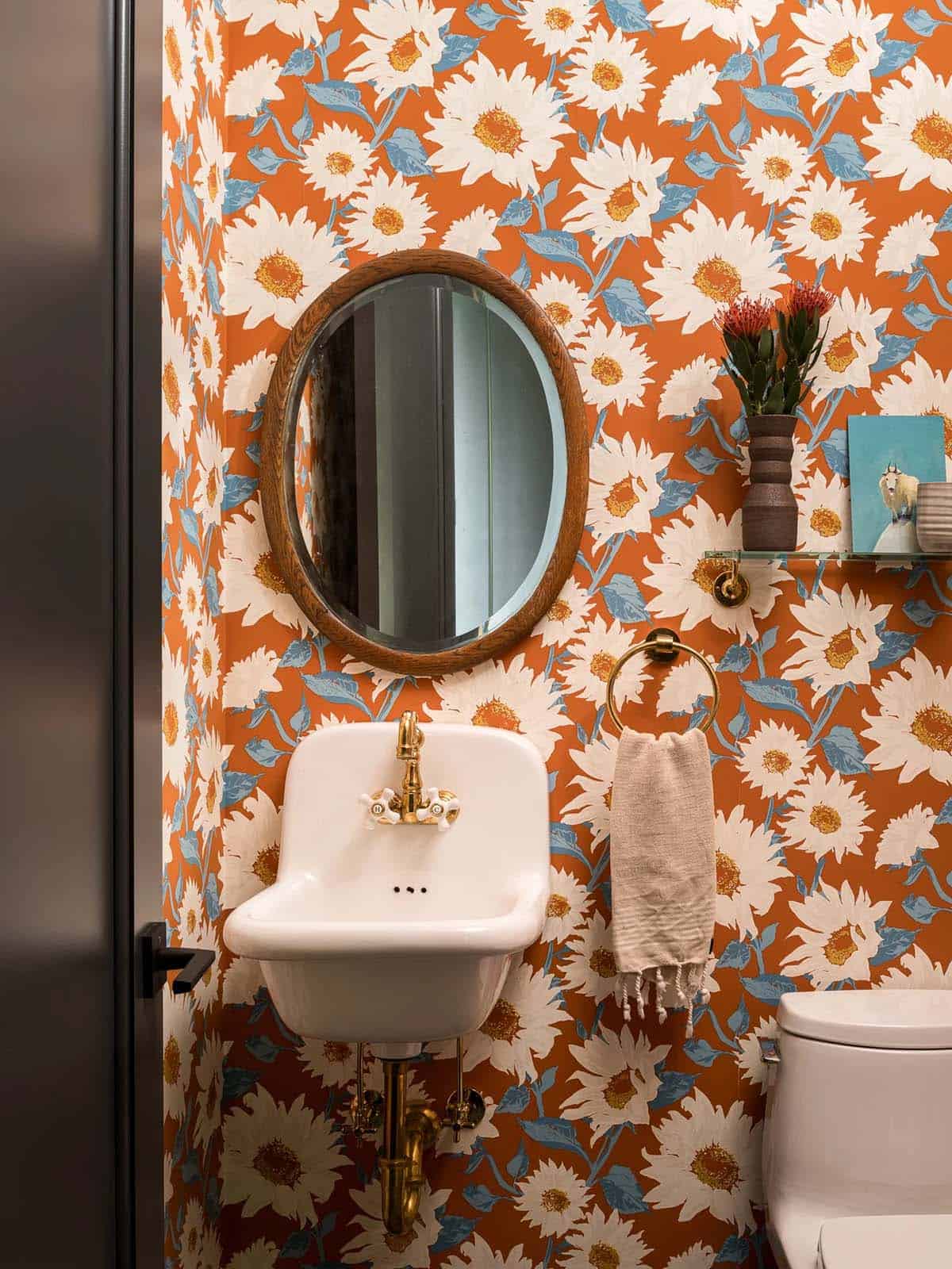 Powder room with floral wallpaper and vintage brass fixtures