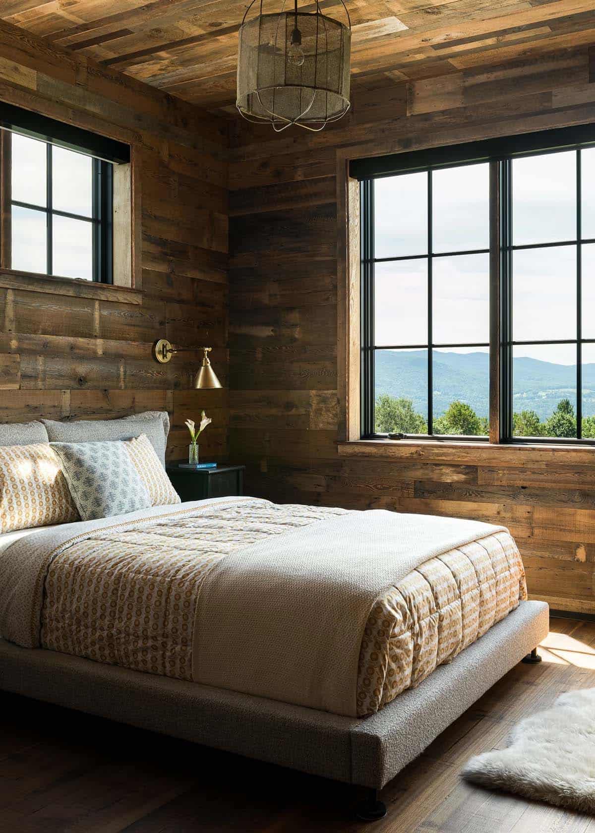Bedroom with reclaimed wood walls and large mountain-view windows