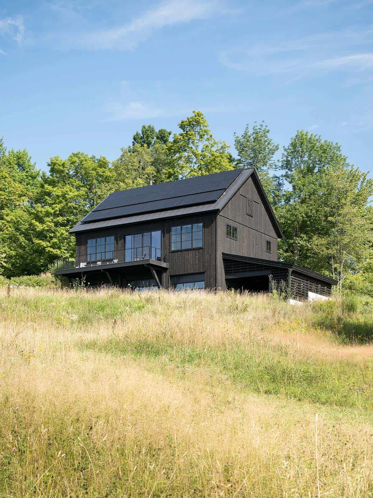 Black barn house exterior set in a sunny meadow