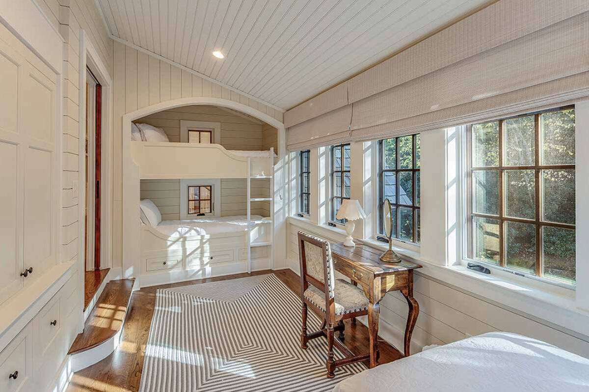 Built-in bunk beds tucked under vaulted shiplap ceiling in bedroom