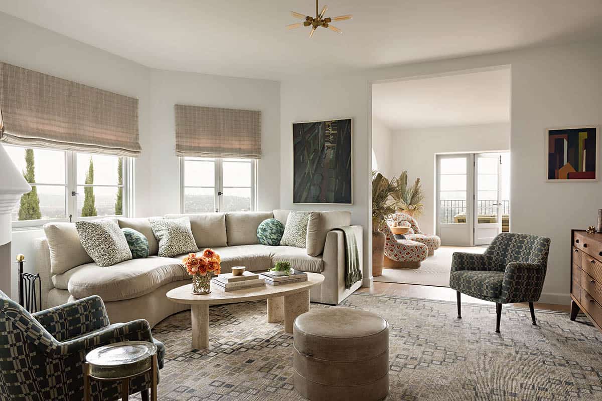 Family room with curved sofa, travertine coffee table, and plaid roman shades