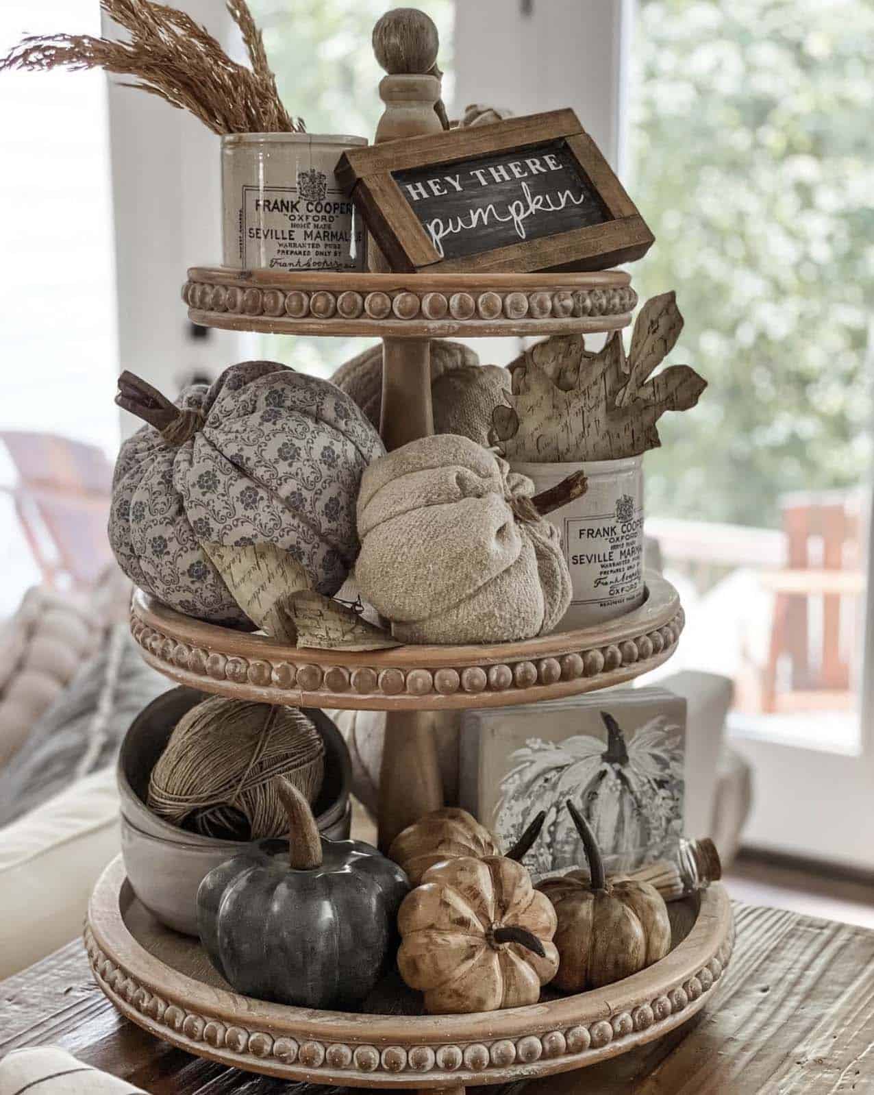 Wood tiered tray with fabric pumpkins, carved gourds, and "Hey There Pumpkin" sign