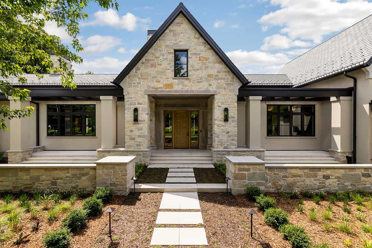 Symmetrical stone entry gable framed by covered side porches