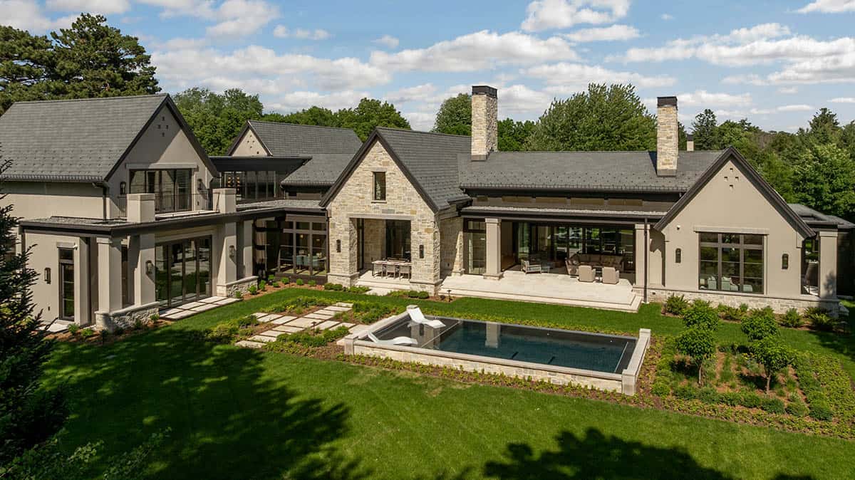 Rear elevation showing stone gables, covered patio, and infinity-edge pool