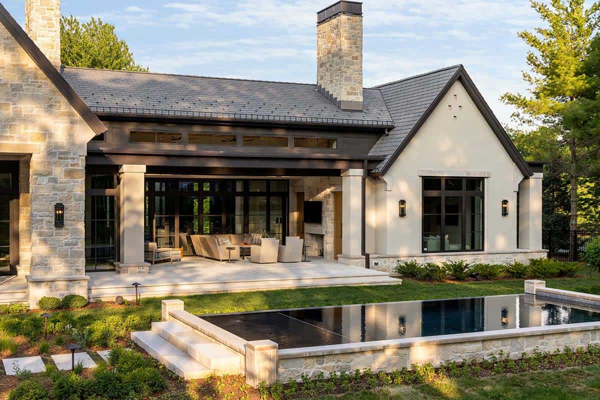 Covered patio with outdoor seating beside dark reflecting pool