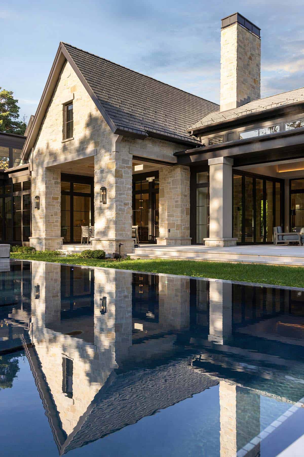 Stone gable and chimney reflected in glassy raised pool
