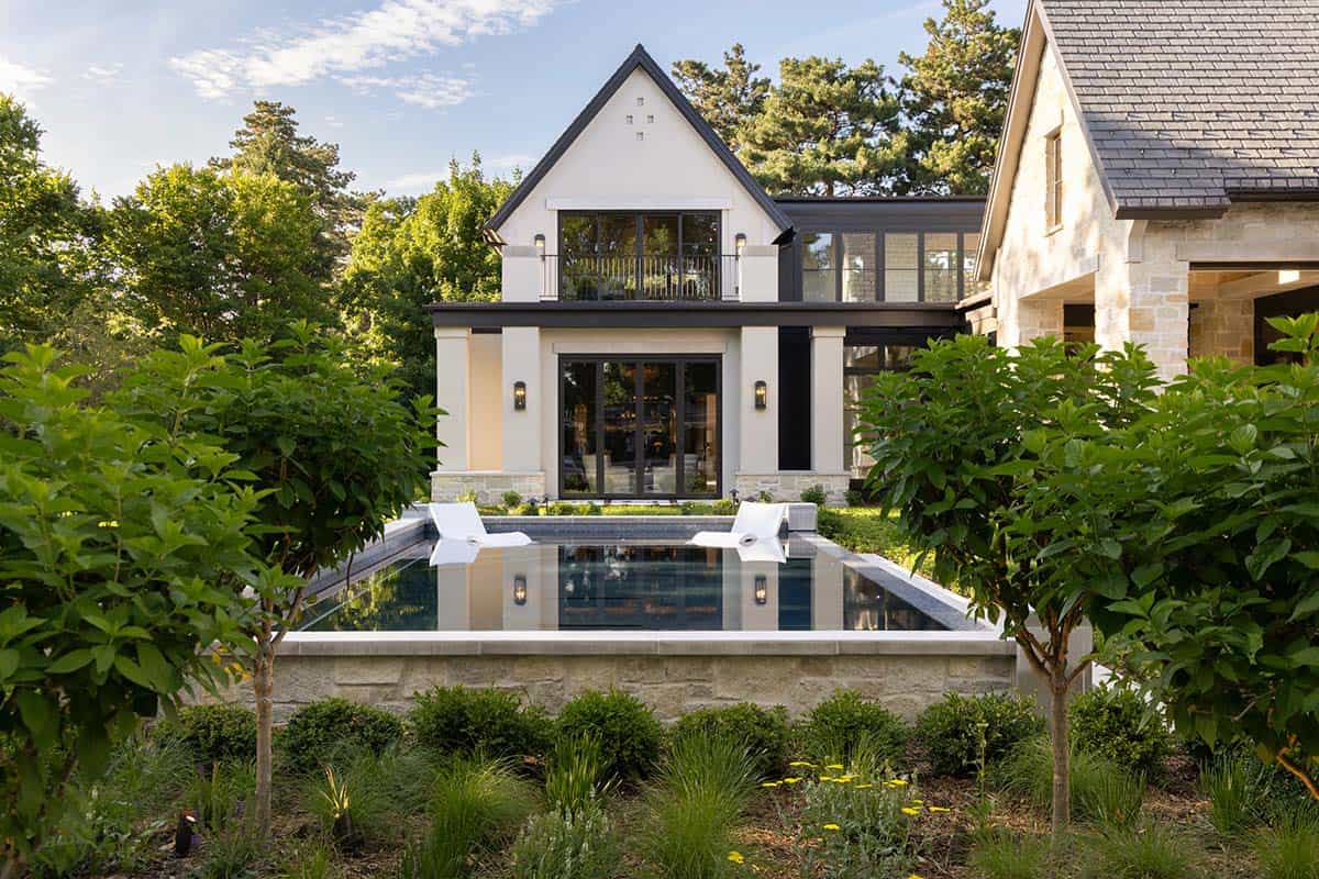 Two-story addition with balcony overlooking raised pool and gardens