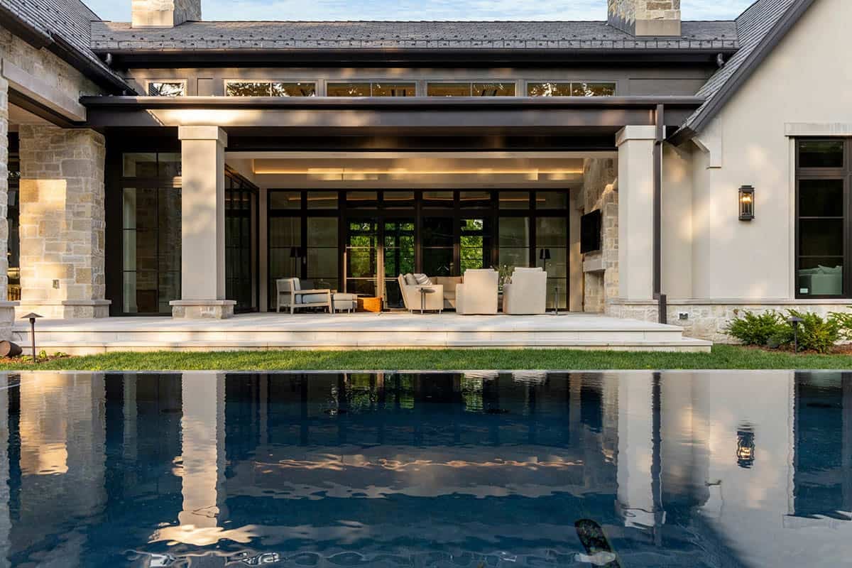 Covered patio lounge reflected in dark infinity-edge pool