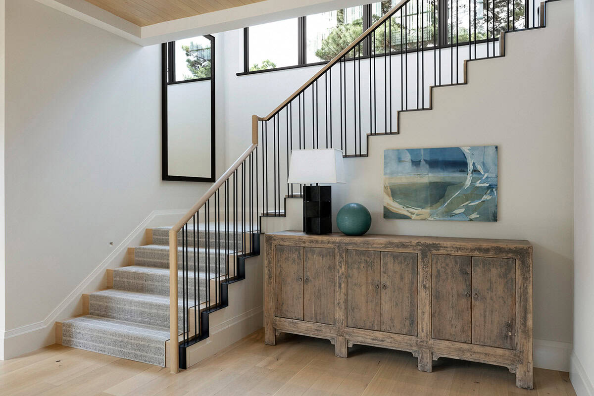 Staircase landing with abstract art above weathered wood console