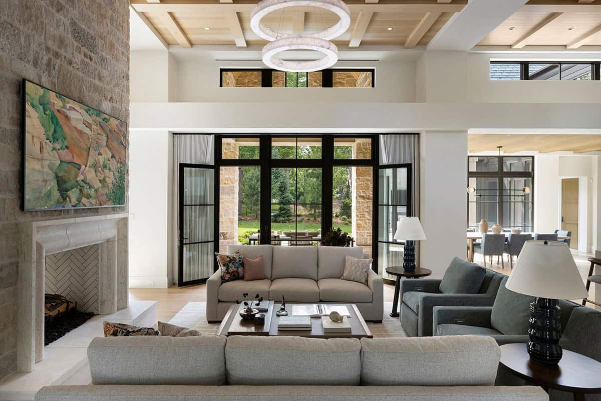 Living room with stone fireplace opening to covered outdoor patio