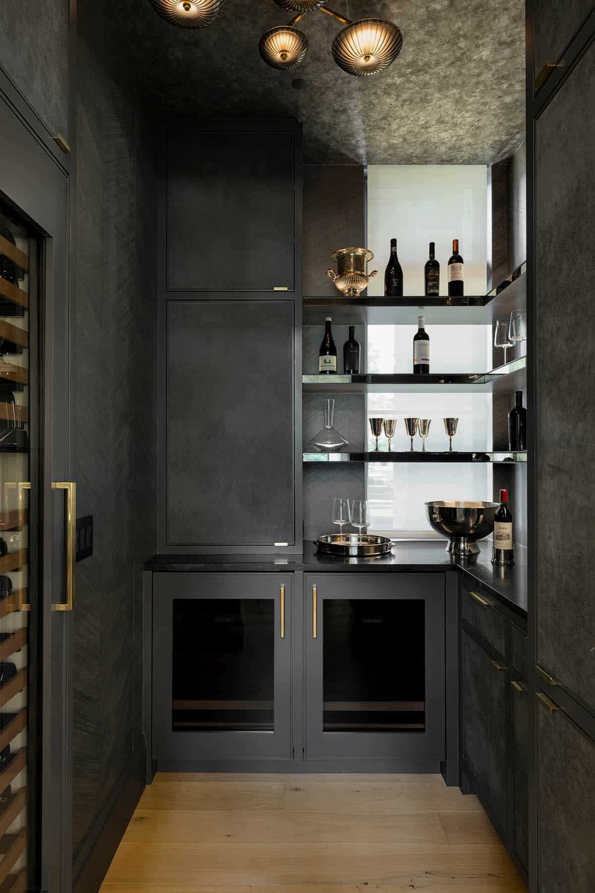 Dark moody butler's pantry with brass hardware and wine storage