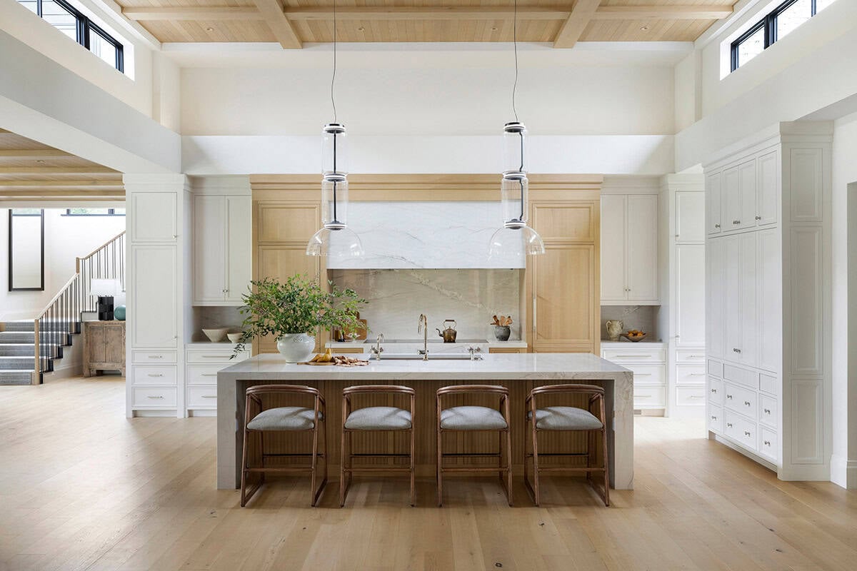 Kitchen island with waterfall marble and glass pendant lighting