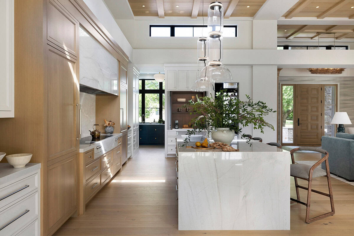 Kitchen galley with white oak cabinetry and marble backsplash
