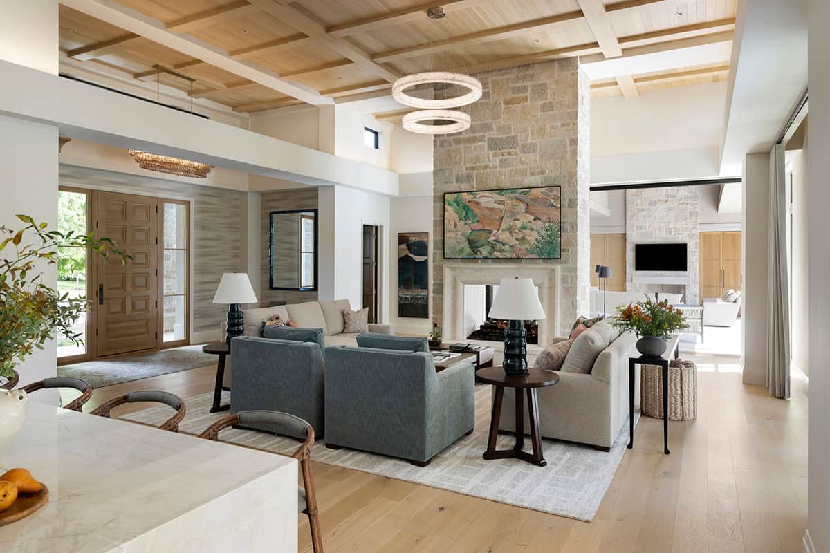 Living room with stone fireplace opening to entry and kitchen