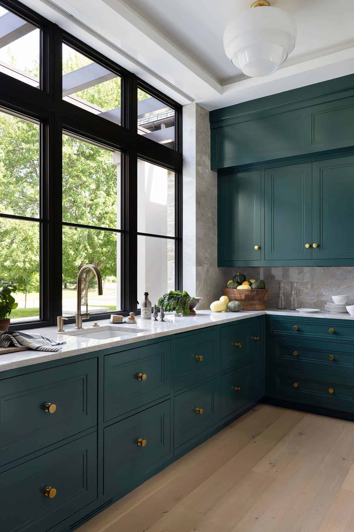 Teal scullery with marble counters and gooseneck brass faucet
