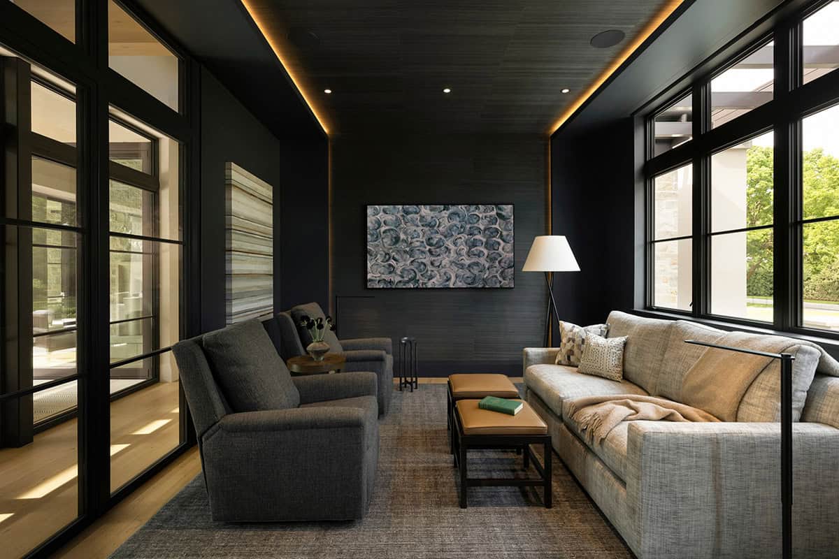 Dark moody media room with abstract art and gray sectional